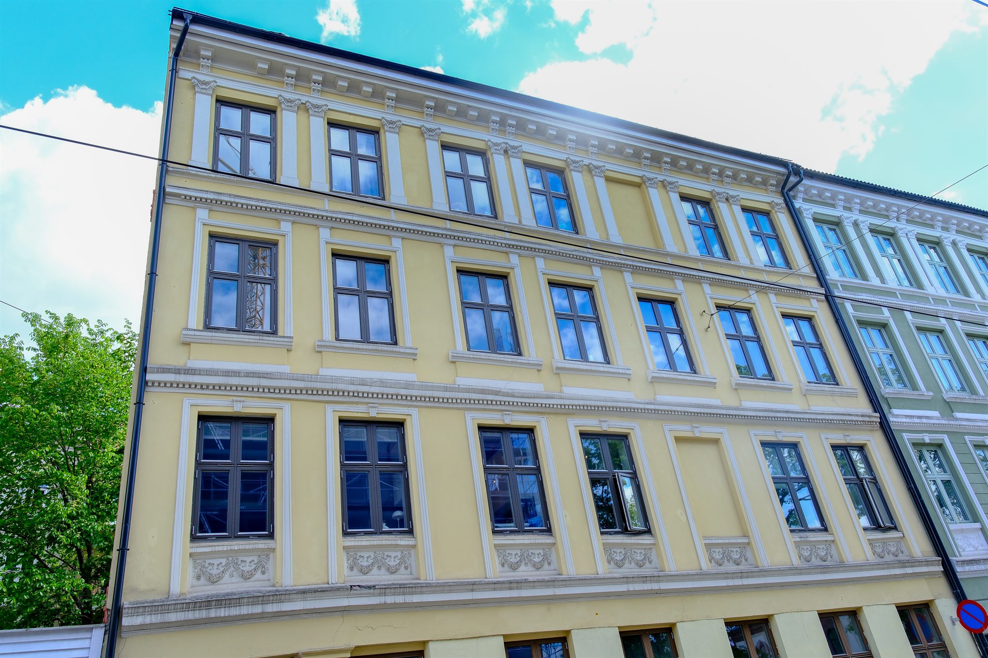 Gul bygård før fasaderehabilitering